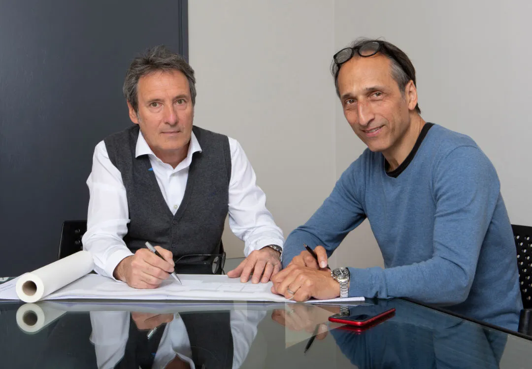 Maurizio Stella e Dario Piccaluga seduti al tavolo con i disegni di un progetto