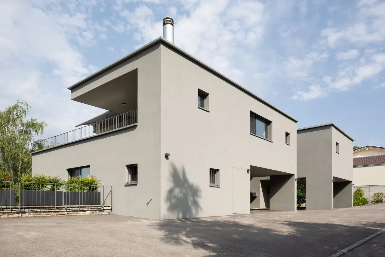 La seconda casa a volumi in intonaco grigio, con la terrazza a sbalzo sopra l'ingresso